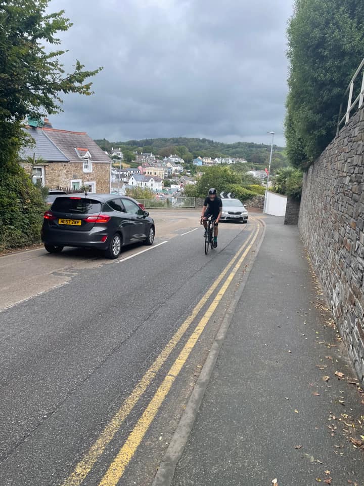 Chris on his bike cycling up a steep hill